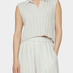Close up front view of speckle beige sleeveless knit vest with collar, open v neckline, and wide ribbing