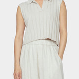 Close up front view of speckle beige sleeveless knit vest with collar, open v neckline, and wide ribbing