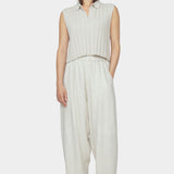 Front view of speckle beige collared knit vest with wide rib texture and cropped fit styled with relaxed light beige pants