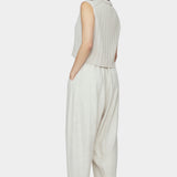 Back and side view of speckle beige sleeveless ribbed knit vest with collar and cropped hem styled with relaxed light beige pants