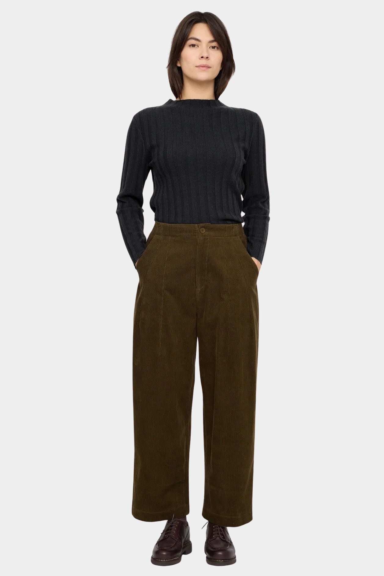 7115 by Szeki Mock Neck Ribbed Long Sleeves Charcoal tucked into brown corduroy trousers.