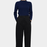 7115 by Szeki Mock Neck Ribbed Long Sleeves Navy tucked into black trousers with mock neckline visible.