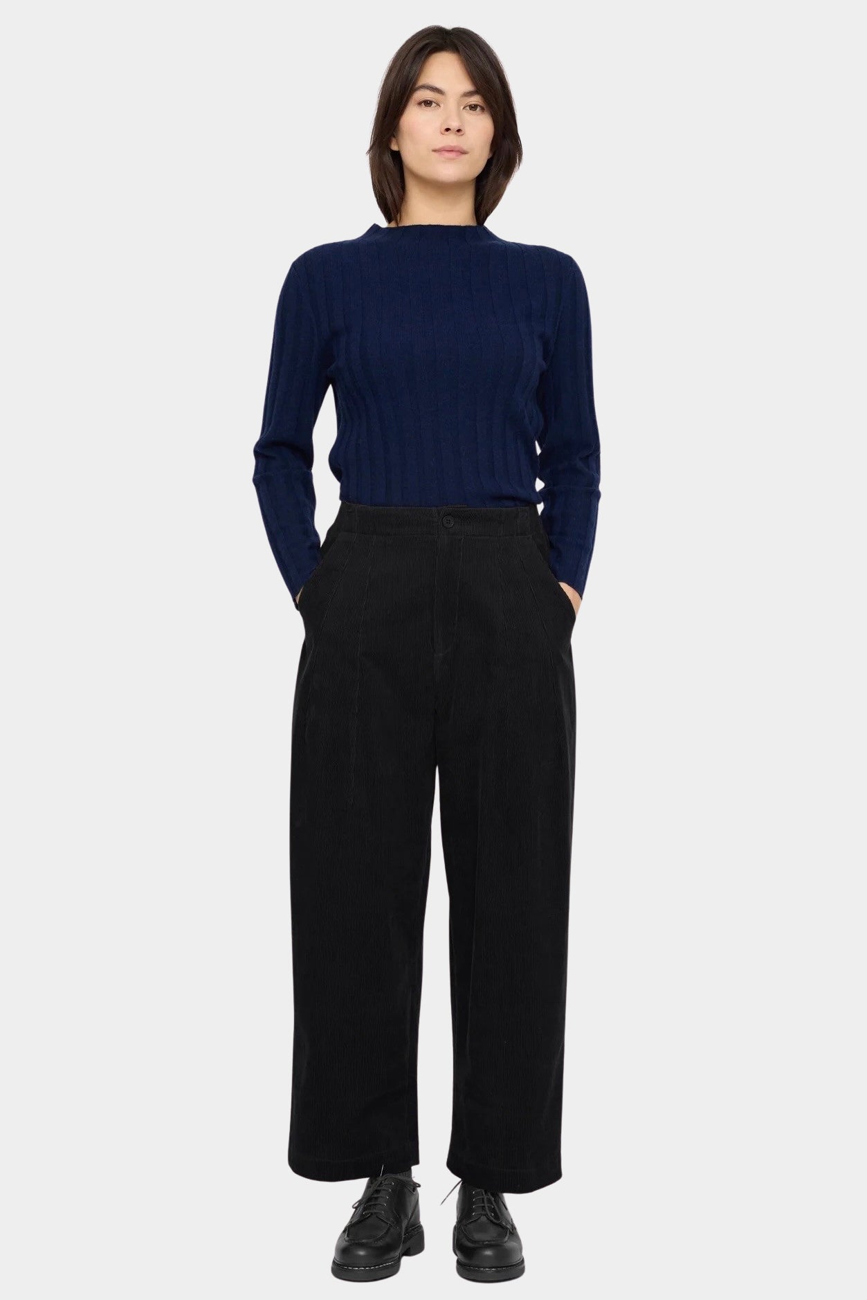 7115 by Szeki Mock Neck Ribbed Long Sleeves Navy tucked into black trousers with mock neckline visible.
