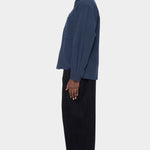 Side view of the navy Relaxed Pocket Shirt showing its boxy shape and buttoned cuff