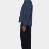 Side view of the navy Relaxed Pocket Shirt showing its boxy shape and buttoned cuff