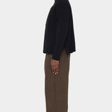 Side view of the black Relaxed Pocket Sweater showing the slit at the hem