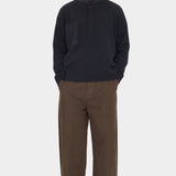 Front view of the black 7115 by Szeki Relaxed Pocket Sweater with brown trousers at YUCCA Denver