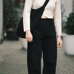 Front detail of the black Signature Curve Legged Work Trouser showing its fixed waist and curved leg at YUCCA Denver