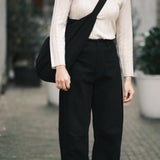 Front detail of the black Signature Curve Legged Work Trouser showing its fixed waist and curved leg at YUCCA Denver