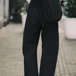 Back view of the black curved leg trouser showing a patch pocket and the tapered hem