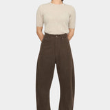 Front view of the Taupe Brown curved leg trouser styled with a cream short sleeve knit at YUCCA Denver