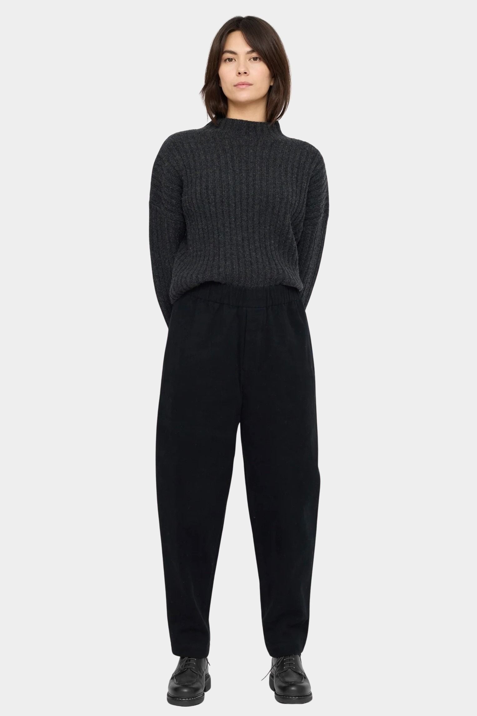 Front view of the black Signature Elastic Pull-Up Trouser with a rounded leg and tapered ankle at YUCCA Denver