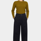 Front view of the black cotton trouser with hands in the side pockets and a relaxed straight leg