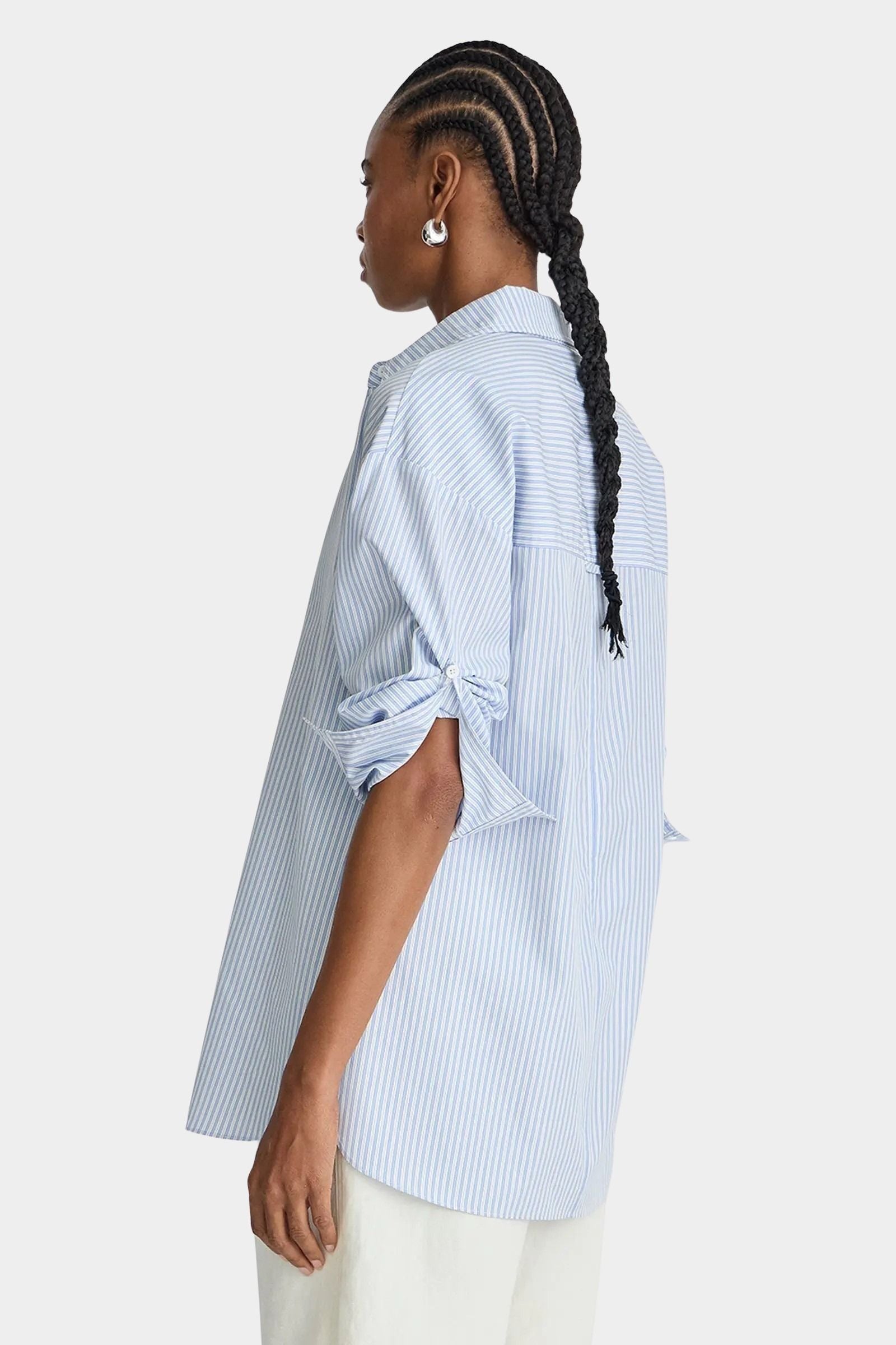 Apiece Apart Isolde Button Down Blue and White Stripes side profile with rolled sleeves and oversized fit