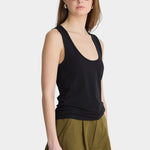 Side view of Apiece Apart Uri Low-Cut Tank Black with fitted stretch silhouette and olive shorts