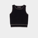 Atelier Delphine knit tank top in black and tan flat lay showing cropped silhouette and contrast stitching detail