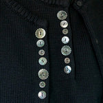 Close view of carved shell buttons on the black DEMYLEE Soleil cotton cardigan