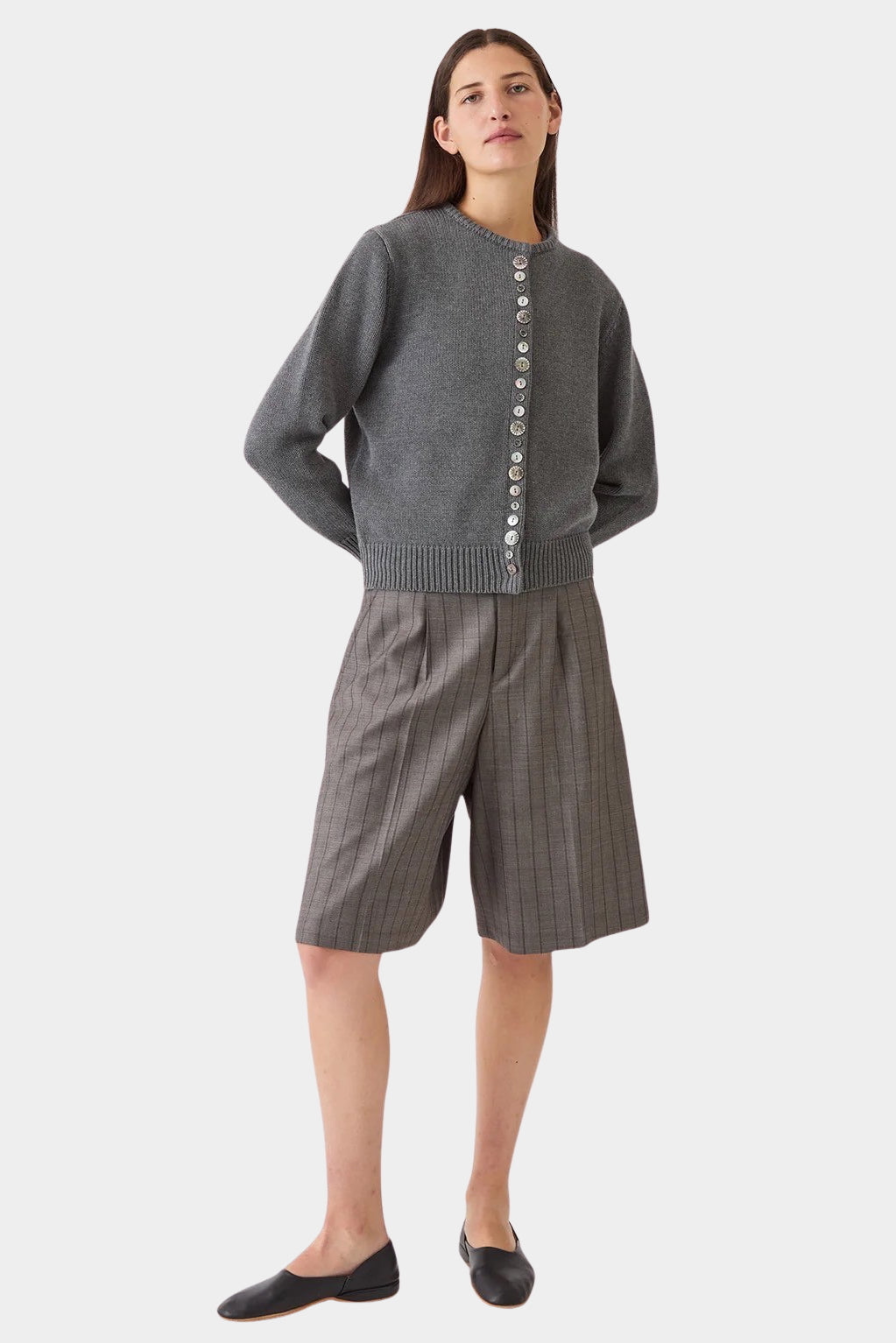 Model wearing the DEMYLEE Soleil cotton cardigan in charcoal with tailored knee length shorts