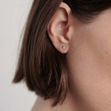 Model wearing gold disc stud earrings styled for everyday minimalist look.