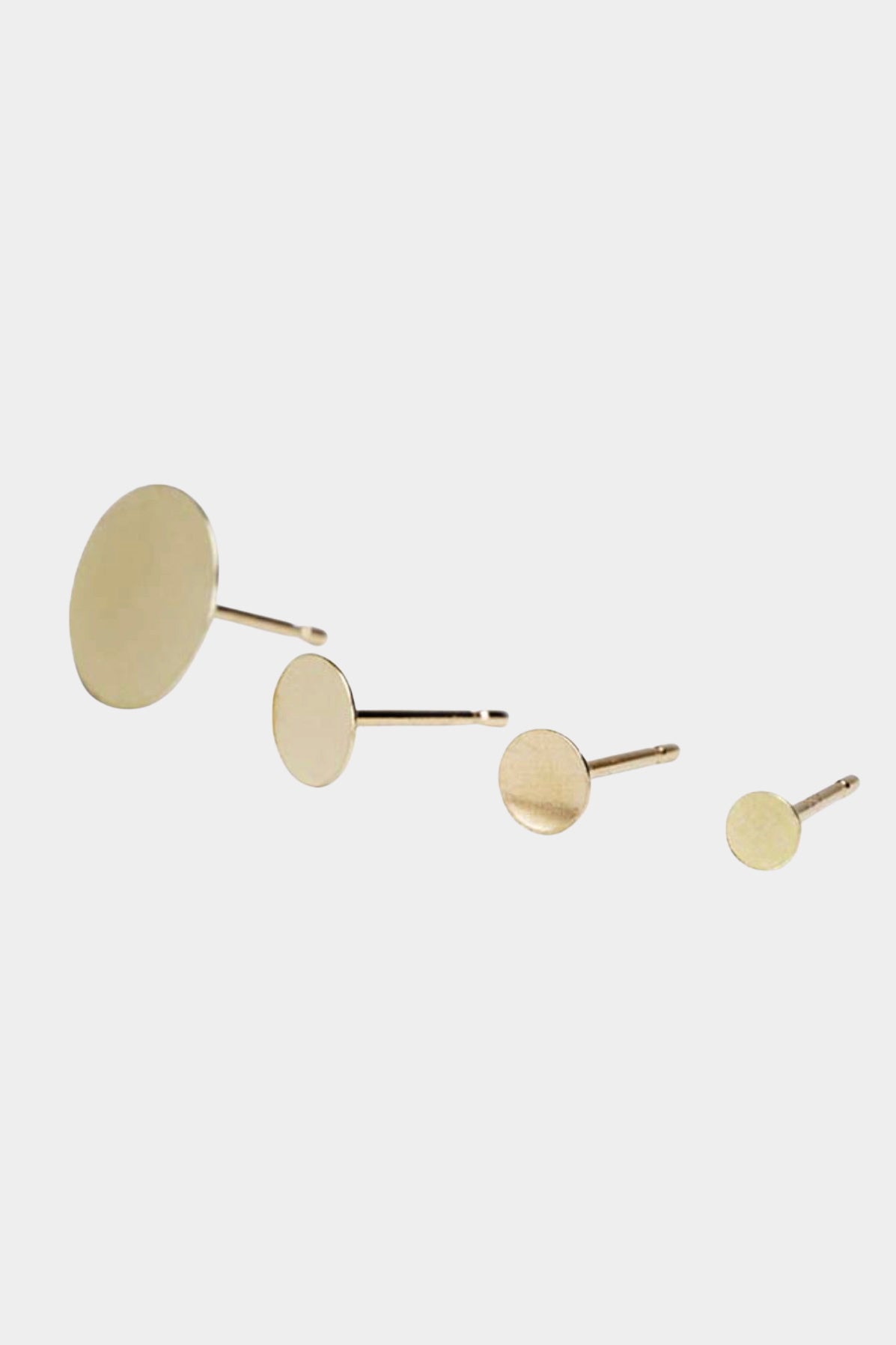 Minimalist gold disc stud earrings in multiple sizes with matte finish.