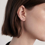 Model wearing delicate 14K gold T-bar stud earring.