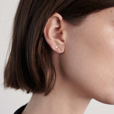 Model wearing delicate 14K gold T-bar stud earring.