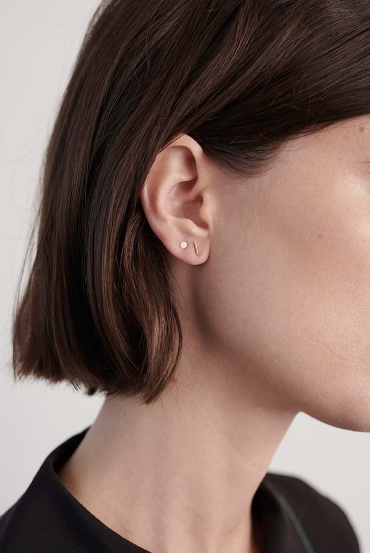 Model wearing delicate 14K gold T-bar stud earring.