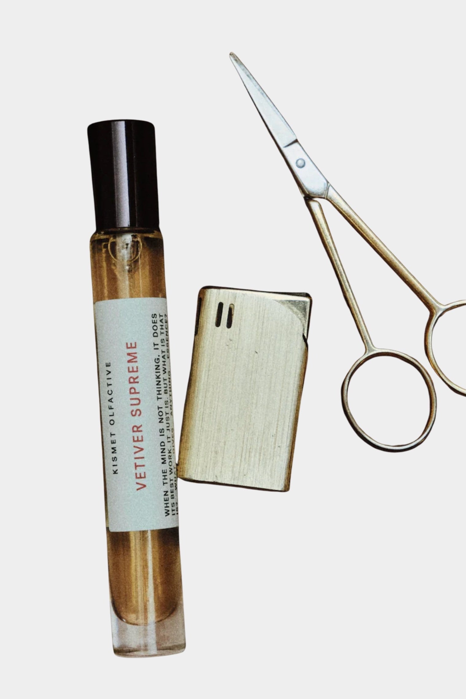 Kismet Olfactive Vetiver Supreme eau de parfum 10ml travel spray with cap removed next to metal scissors on neutral background