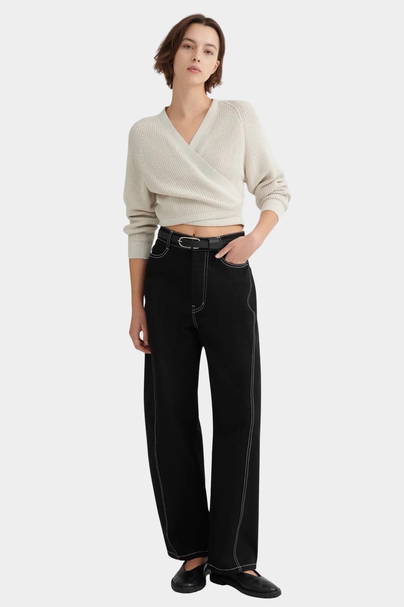 Full front view of the Oatmeal Kowtow Composure Cardigan tied above black wide leg trousers.