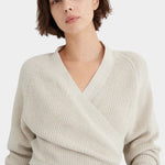 Three-quarter front view of the Oatmeal Kowtow Composure Cardigan styled with black trousers.