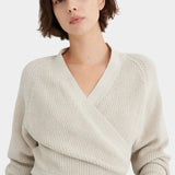 Three-quarter front view of the Oatmeal Kowtow Composure Cardigan styled with black trousers.