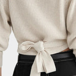 Close back detail of the Oatmeal Kowtow Composure Cardigan showing the tied waist and tuck stitch knit.