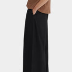 Side view of the black Kowtow Drape Pant showing its wide leg and side seam pocket.
