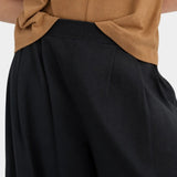 Close view of the black Kowtow Drape Pant showing the ribbed waistband and front pleats.