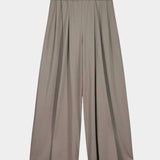 Front product view of the Kowtow Drape Pant in Flint, showing the pleated wide legs and elastic waistband at YUCCA Denver.
