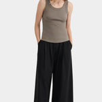 Full front view of the Flint Kowtow Everyday Singlet styled with black wide leg pants.