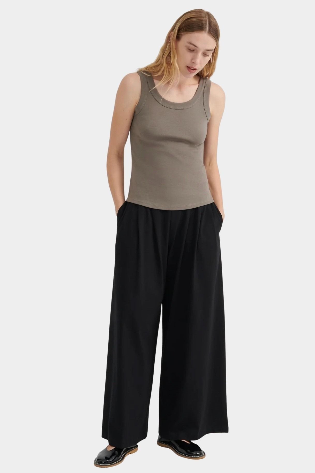 Full front view of the Flint Kowtow Everyday Singlet styled with black wide leg pants.