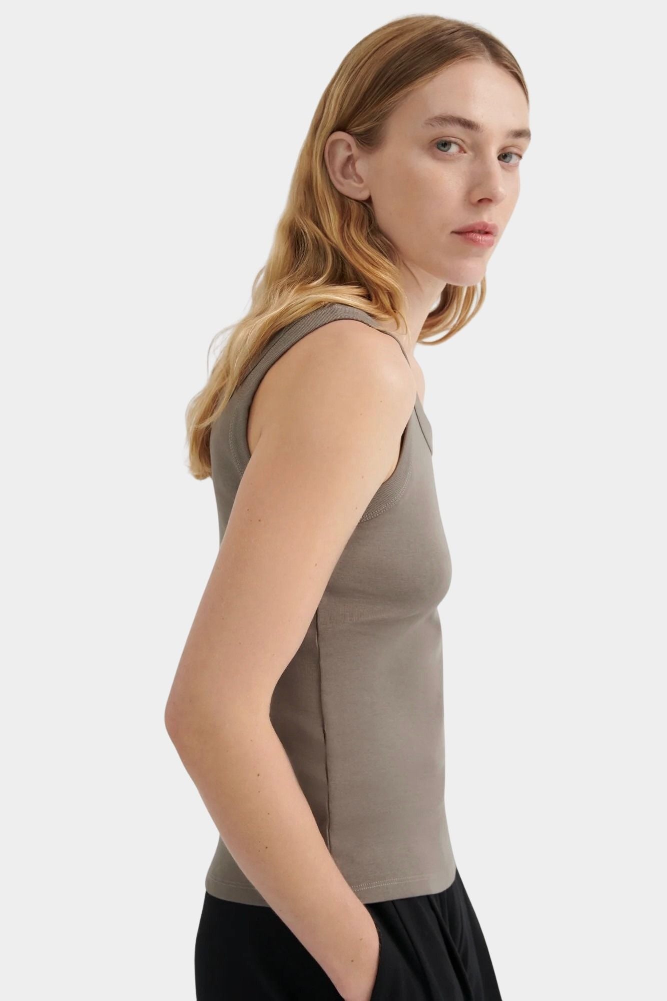 Side view of the Kowtow Everyday Singlet in Flint showing its close fit and finished armhole.