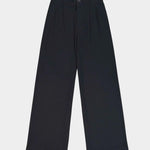 Close view of the black Kowtow Franz Pant showing its high waistband, nut button and front pleats at YUCCA Denver.