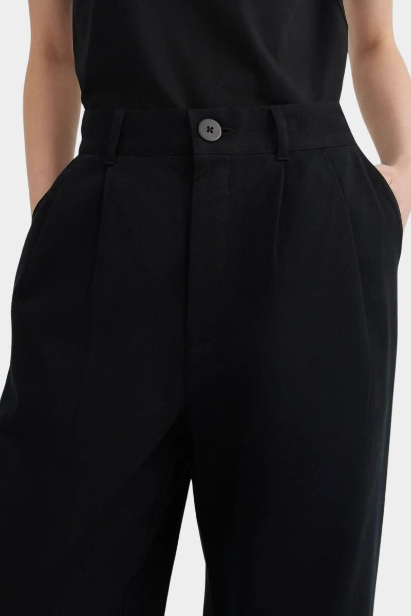 Close view of the black Kowtow Franz Pant showing its high waistband, nut button and front pleats at YUCCA Denver.