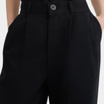 Close view of the black Kowtow Franz Pant showing its high waistband, nut button and front pleats at YUCCA Denver.