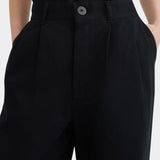 Close view of the black Kowtow Franz Pant showing its high waistband, nut button and front pleats at YUCCA Denver.