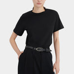 Close front view of the black Kowtow Franz Pant styled with a tucked black tee and belt.