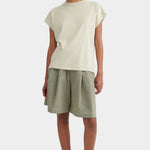 Model wearing the Stone Kowtow Geometry Tee with sage shorts and black Mary Janes at YUCCA Denver