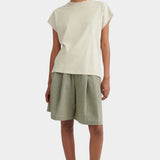 Model wearing the Stone Kowtow Geometry Tee with sage shorts and black Mary Janes at YUCCA Denver