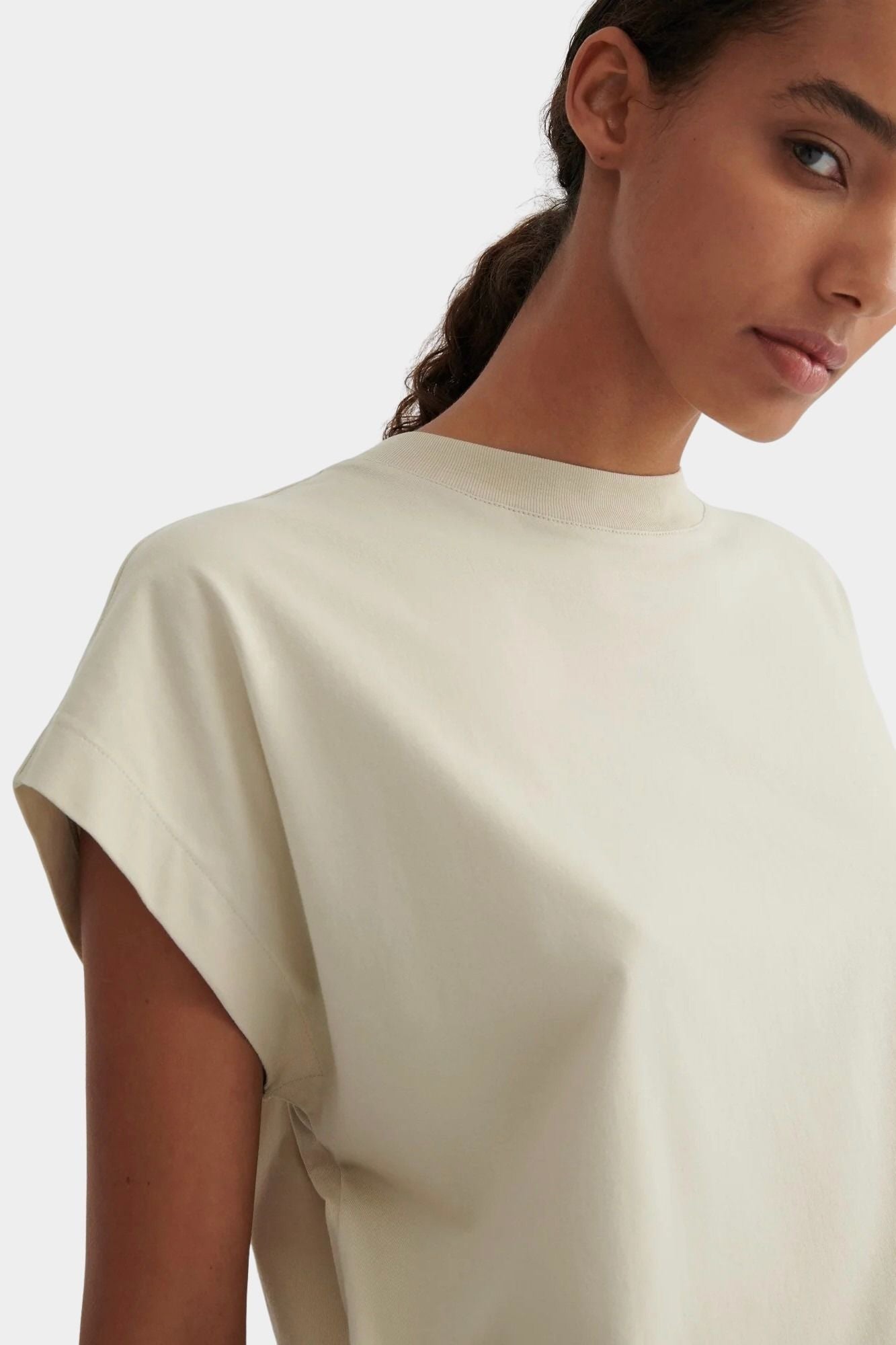 Close view of the ribbed neckline and soft cap sleeve shape of the Stone Kowtow Geometry Tee