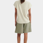 Back view of the Stone Kowtow Geometry Tee worn with sage shorts