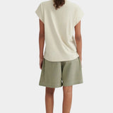 Back view of the Stone Kowtow Geometry Tee worn with sage shorts