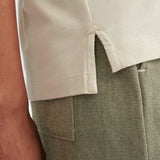Close view of the side split at the hem of the Stone Kowtow Geometry Tee