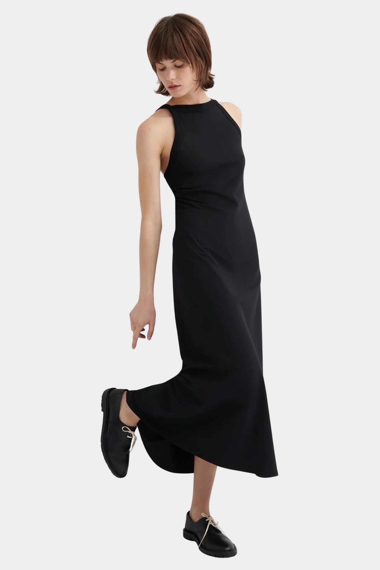 Kowtow Low Back Dress in black worn with black lace up shoes, full length front view